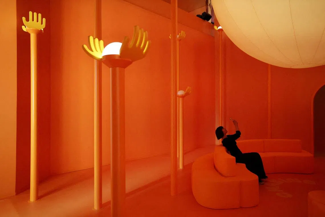 A woman sitting on a sofa at the Veuve Clicquot "Chasing the Sun" installation, in collaboration with British-Nigerian artist and designer Yinka Ilori, as part of the Milan Design Week Fuorisalone exhibition, in Milan, Italy, on April 20, 2026.