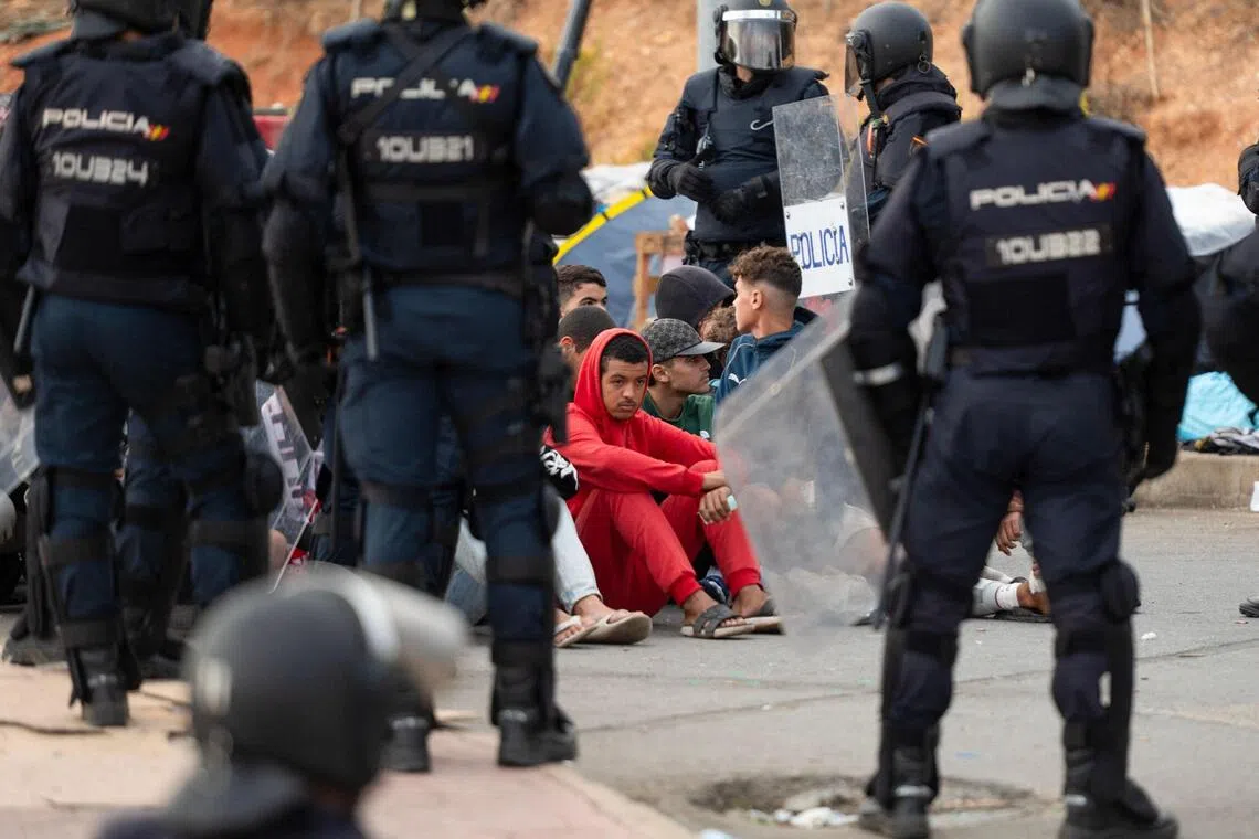 Spanish police rounding up migrants in Spain’s north African enclave of Ceuta on Oct 18.