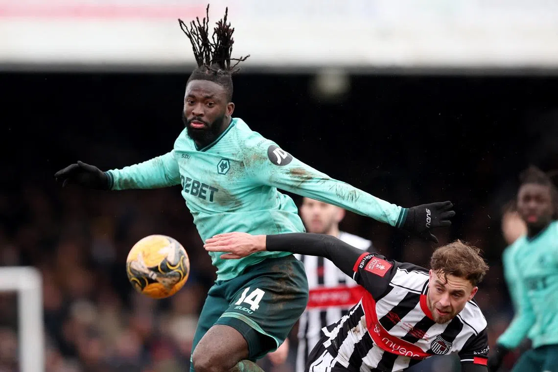 Soccer Football -  FA Cup - Fourth Round - Grimsby Town v Wolverhampton Wanderers - Blundell Park, Cleethorpes, Britain - February 15, 2026 Wolverhampton Wanderers' Tolu Arokodare in action with Grimsby Town's Jamie Walker REUTERS/Scott Heppell