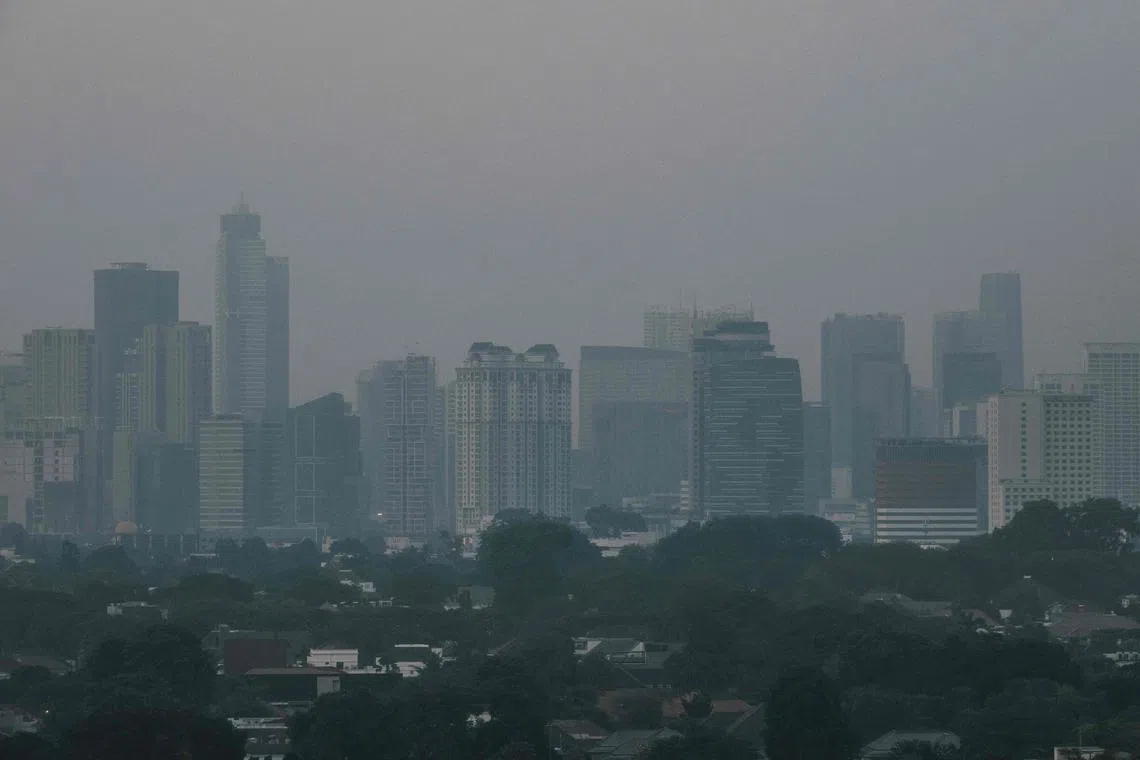 Buildings are seen in the haze caused by the air pollution in Jakarta on August 23, 2023. Thousands of public employees in Indonesia's capital, or half of its civil servants, were told to work from home starting on August 21 in a two-month trial aimed at improving the city's air quality, a government notice said. (Photo by Yasuyoshi CHIBA / AFP)