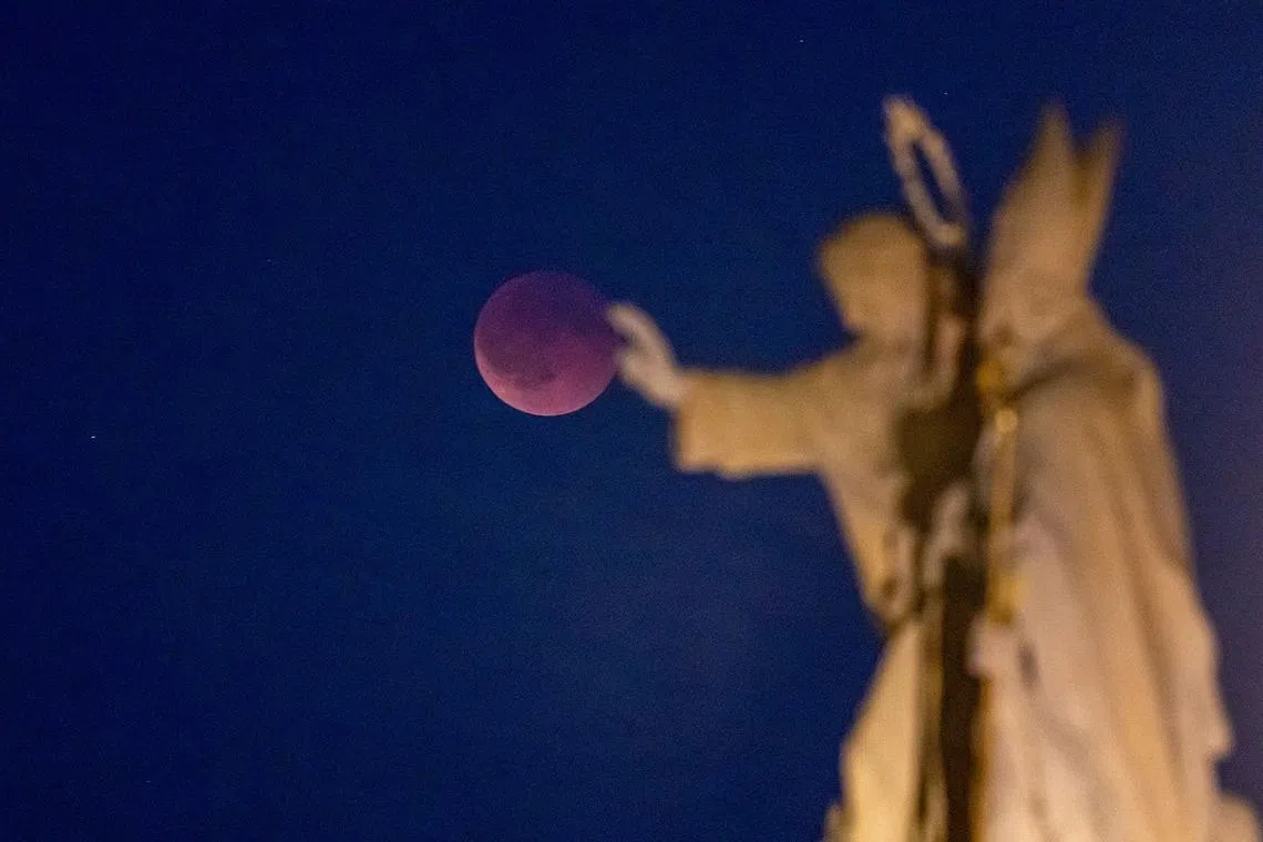 The blood moon is seen during a total eclipse over the city center in Prague, Czech Republic, on Sept 7, 2025. L