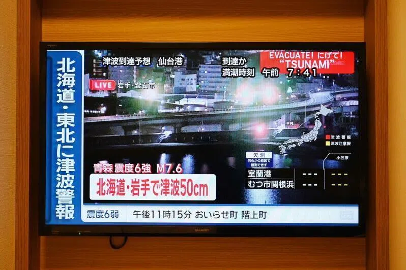 A tsunami warning flashes over live footage of a waterfront area, on a TV screen in Sapporo, in Japan’s northern Hokkaido prefecture on Dec 9.
