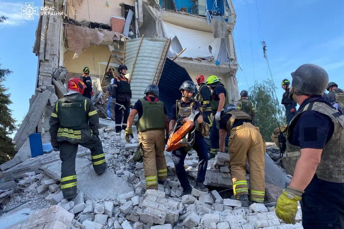 Rescuers work at the site of a Russian missile strike in Kryvyi Rih, Ukraine, on Sept 27.