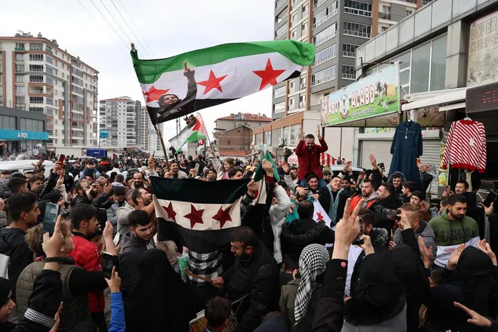 epa11764538 Apoiadores da oposição síria residentes na Turquia agitam a bandeira síria da oposição e celebram a tomada rebelde de Damasco em Ancara, Turquia, 8 de dezembro de 2024. Os rebeldes sírios entraram em Damasco em 8 de dezembro de 2024 e anunciaram numa declaração televisiva a 'Libertação da cidade de Damasco e o derrube de Bashar al-Assad', bem como a libertação de todos os prisioneiros. Os rebeldes também instaram as forças armadas sírias a abandonarem as instituições públicas sírias, que permanecerão sob o controlo do primeiro-ministro sírio cessante até à cerimónia oficial de entrega. EPA-EFE/NECATI SAVAS