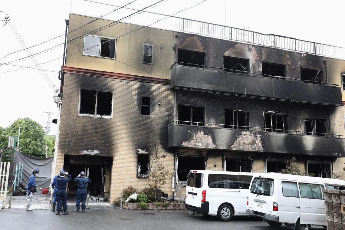 Japanese police officers inspect the scene where 36 people died in a fire at the Kyoto Animation studio building in Kyoto on July 19, 2019. 