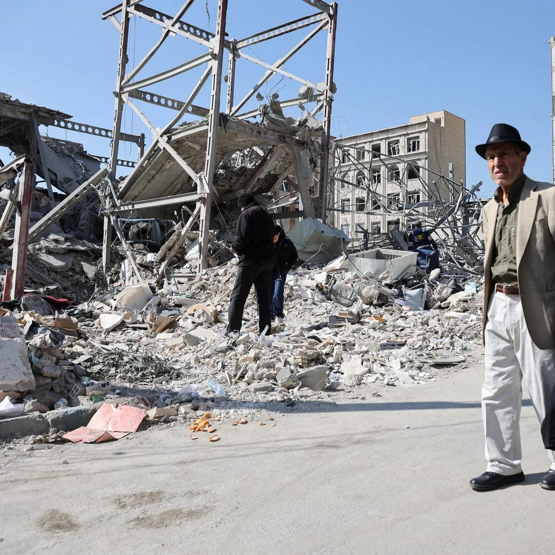 People walk past debris in the aftermath of a strike on a police station, amid the U.S.-Israeli conflict with Iran, in Tehran, Iran, March 4, 2026. Majid Asgaripour/WANA (West Asia News Agency) via REUTERS