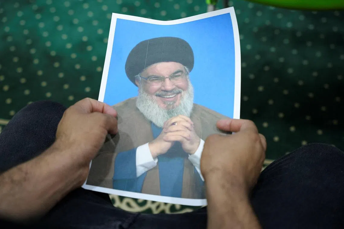 FILE PHOTO: An Iraqi volunteer holds a picture of Lebanon's Hezbollah leader Sayyed Hassan Nasrallah, who has been killed, while registering his name to support Hezbollah, following a call from the Jihad and Construction Movement, a Shi'a Islamist Iraqi political party, in Basra, Iraq, on September 27, 2024. REUTERS/Essam al-Sudani/Fille Photo