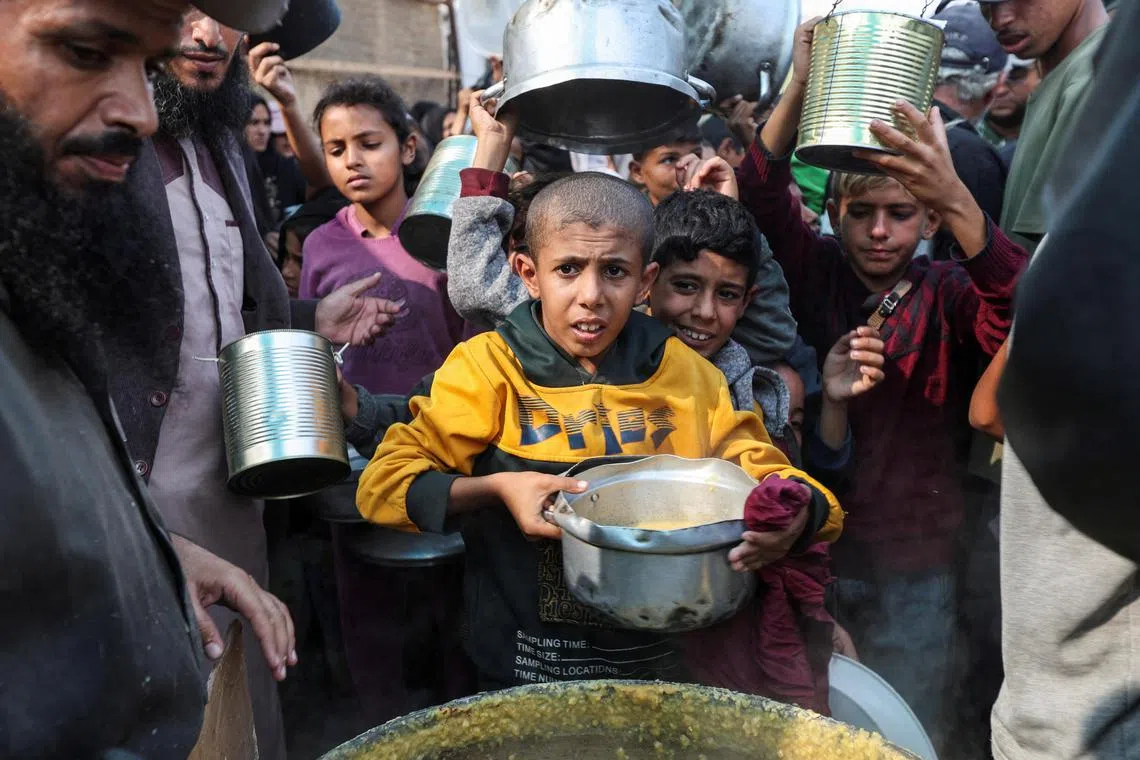 Palestinians gathering to receive meals cooked by a charity kitchen, in the central Gaza Strip, on Nov 10.