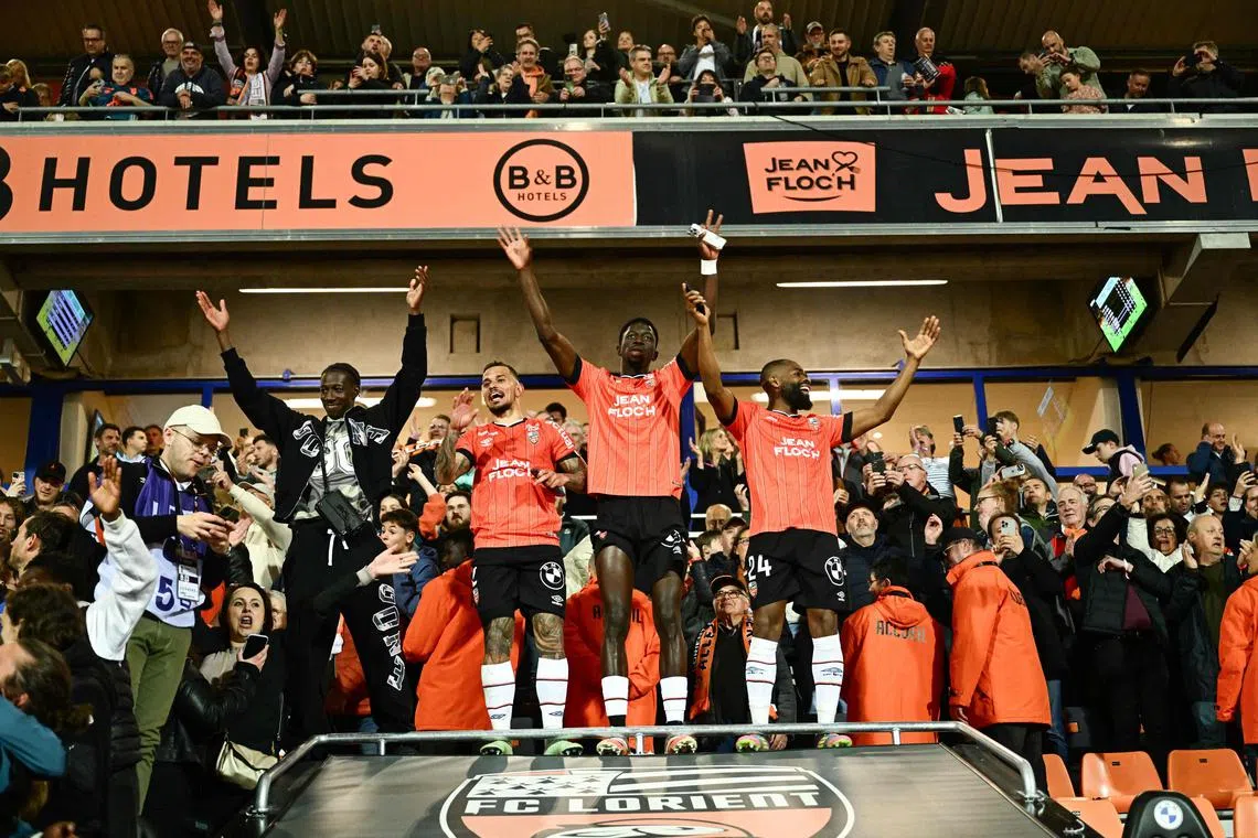 Lorient players celebrate with supporters after beating Caen 4-0 in their Ligue 2 match at the Stade du Moustoir-Yves Allainmat in Lorient on April 26, 2025 to earn promotion to Ligue 1 at the first time of asking.
