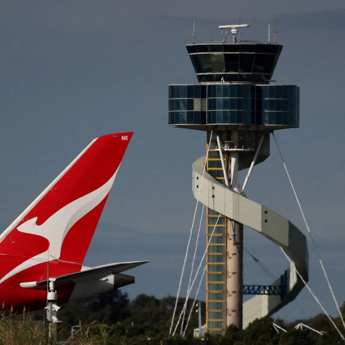 FILE PHOTO: A Qantas plane passes an air traffic control tower as it taxis along a runway Sydney Airport, in Sydney, Australia, August 21, 2026.  REUTERS/Hollie Adams/File Photo