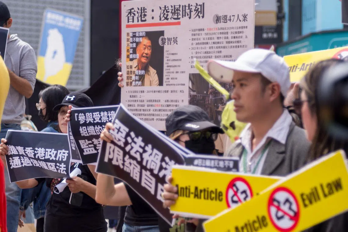 People holding placards and a poster showing Jimmy Lai, protest against the new national security law, in Taipei, on March 23.