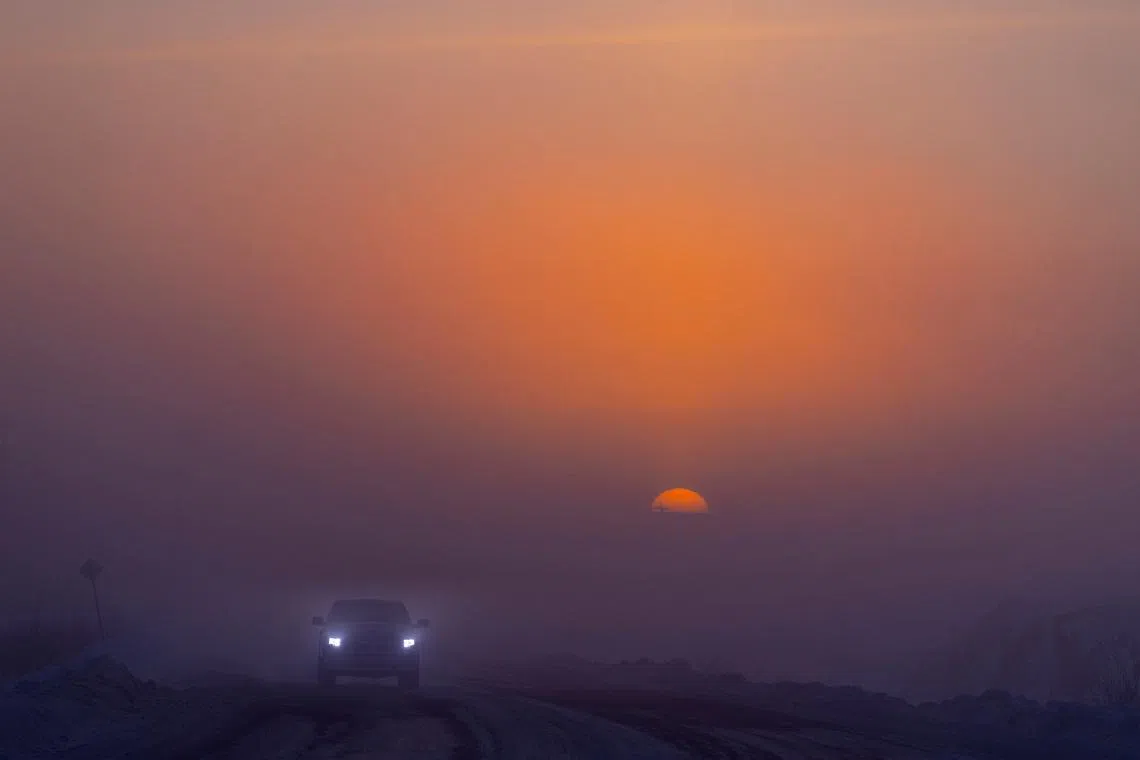 A vehicle travelling along a road at sunrise during an extreme cold weather warning, in Yellowknife, Northwest Territories, Canada, on Feb 18, 2026.