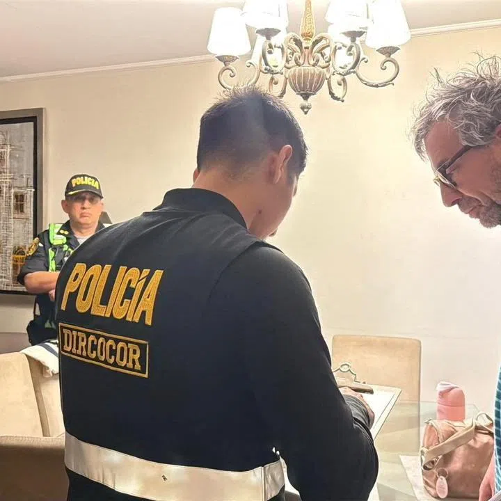 A member of the Peru National Police speaks with Piero Corvetto, the former head of Peru’s National Office of Electoral Processes (ONPE), during a raid at his residence as part of a new investigation into alleged electoral irregularities, after he resigned this week over delays in counting votes from the April 12 general election, in Lima, Peru, in this handout distributed on April 24, 2026. Policia Nacional de Peru/Handout via REUTERS