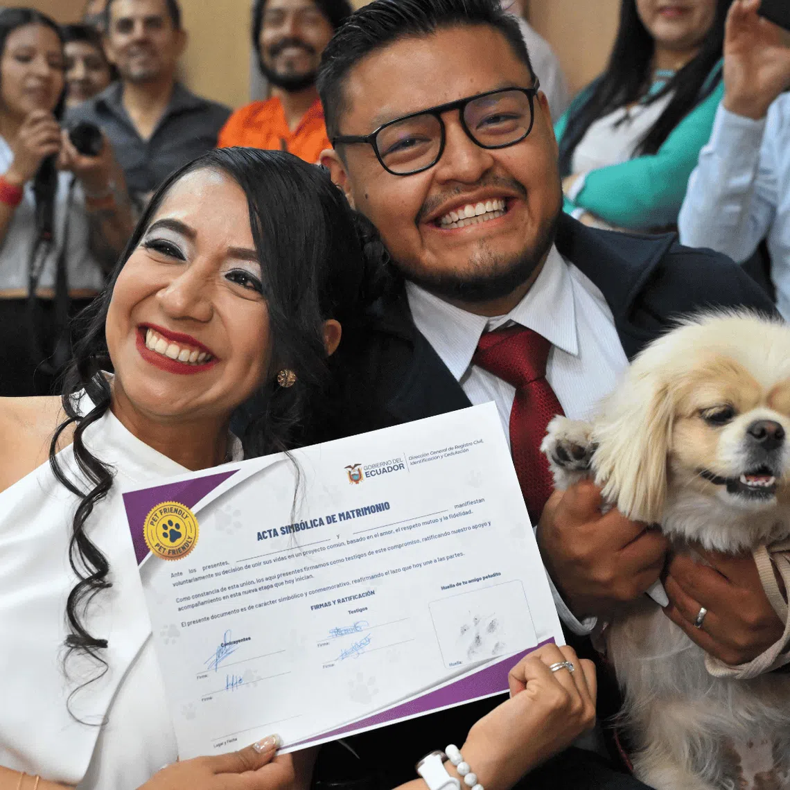 Pet owners show the symbolic marriage certificate with their pet’s “signature” after their wedding at the central civil registry office in Quito on July 7.