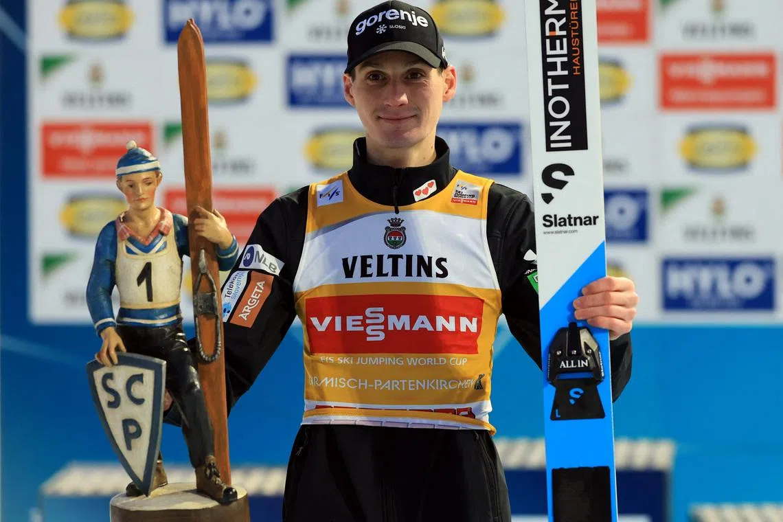 Ski Jumping - Four Hills Tournament - Garmisch-Partenkirchen, Germany - January 1, 2026 Slovenia's Domen Prevc celebrates on the podium with the trophy after winning the Men's Individual HS142 REUTERS/Kai Pfaffenbach