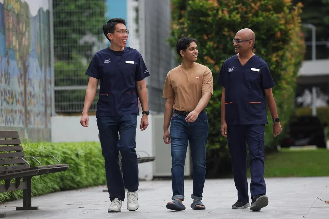 Strolling around the grounds of Ng Teng Fong General Hospital (NTFGH) with his doctors (left) Low Shiong Wen, who heads the Neurosurgery, and anesthetist Harinda Goonesekera (right). Slow walk was something Arshad could not do two years ago.