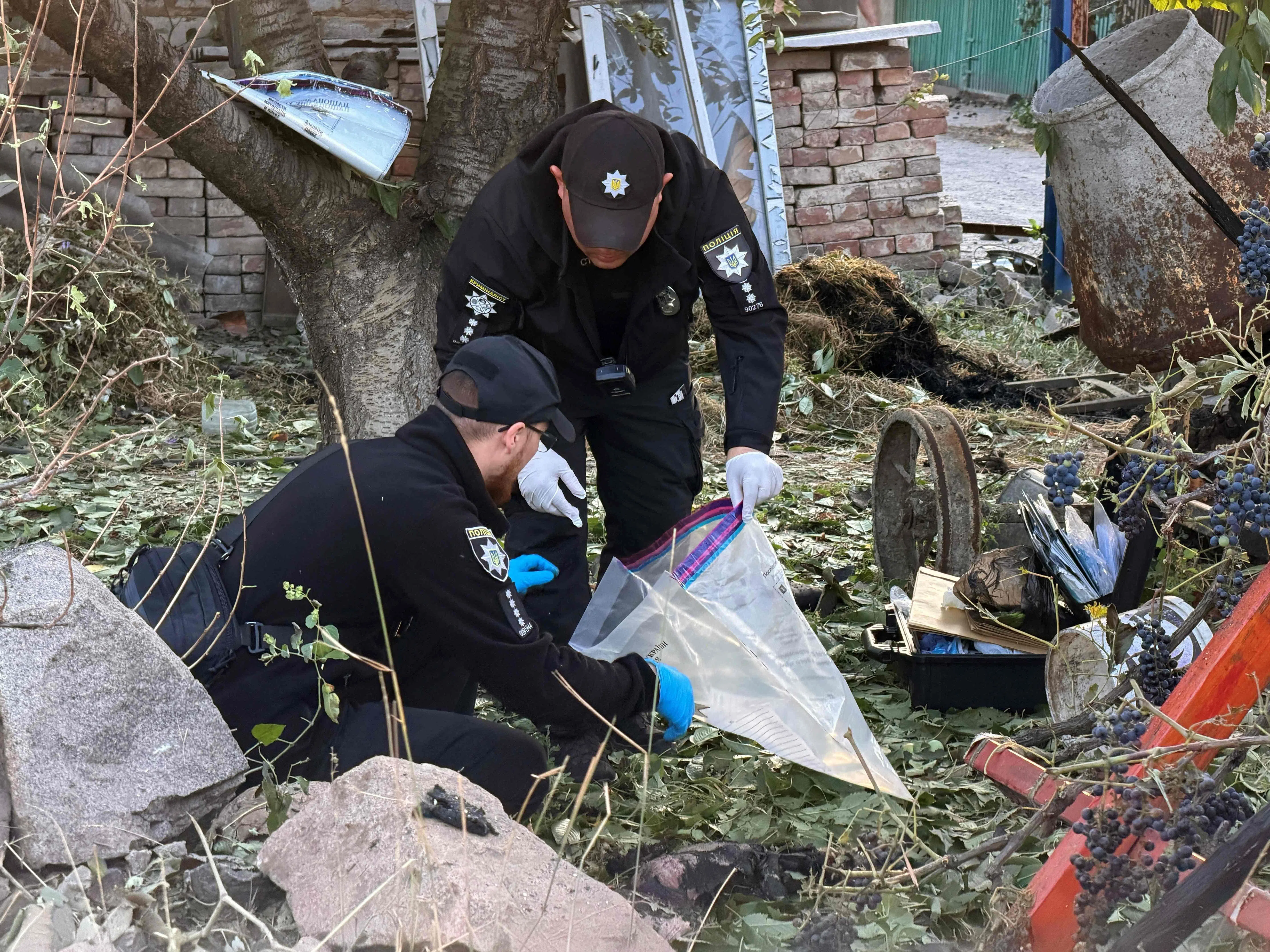 Police experts examining the remains of a private home in Zaporizhzhia, Ukraine, where two people died in an air strike early on Sept 12.