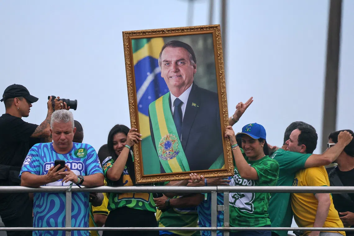 People hold up a portrait of former Brazilian President Jair Bolsonaro during the closing presidential campaign rally of his son Flavio Bolsonaro, from the Liberal Party (PL), ahead of the presidential runoff, in Rio de Janeiro, Brazil, October 24, 2026. REUTERS/Raquel Cunha