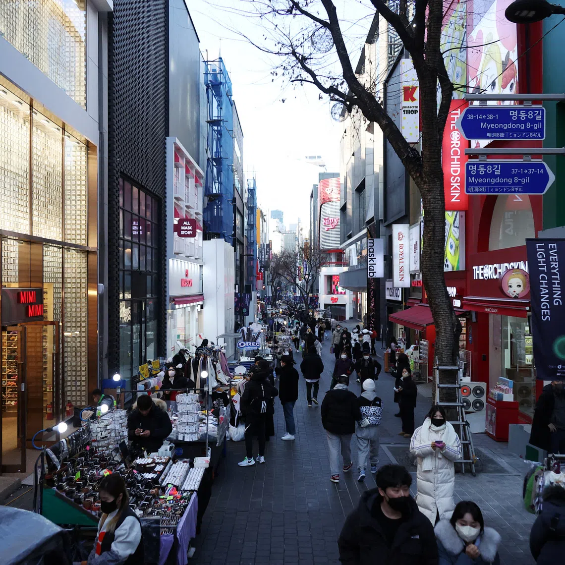 FILE PHOTO: Street vendors (L) wait for customers at Myeongdong shopping district in Seoul, South Korea, January 9, 2023.    REUTERS/Kim Hong-Ji/ File Photo