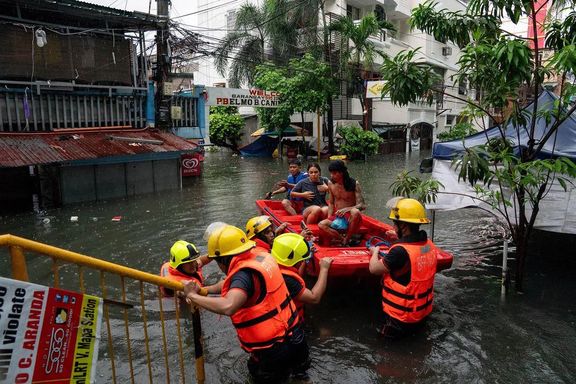 Rescuers assisting residents along a flooded street amid heavy rains brought by Typhoon Gaemi, in Manila, on July 24, 2024. 