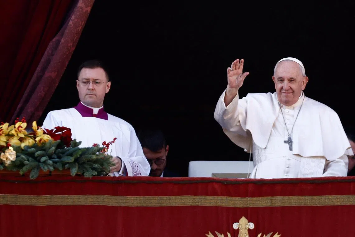 Pope Francis waves as he delivers his traditional Christmas Day Urbi et Orbi message to the city and the world from the main balcony of St. Peter's Basilica at the Vatican, December 25, 2022. REUTERS/Yara Nardi
