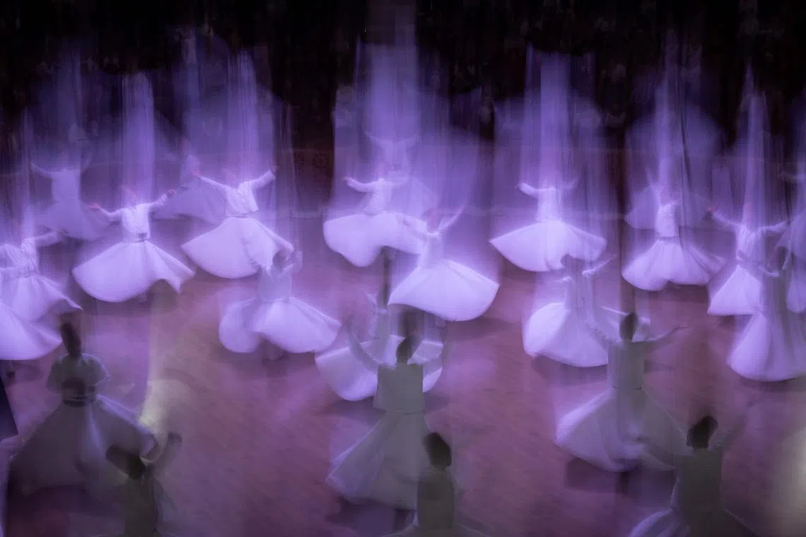 Whirling dervishes performing a "Sema" ritual during a ceremony, one of many marking the 750th anniversary of the death of Mevlana Jalaluddin Rumi, the father of Sufism who lived in the 13th century, at Mevlana Cultural Center in Konya on Dec 16, 2023.