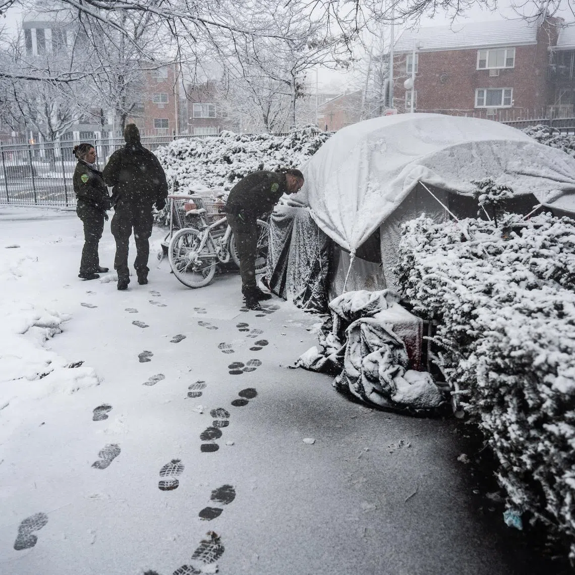 Parks Department officers check on men who had been living in a tent in a park in Queens as a winter storm intensified on Feb 22.