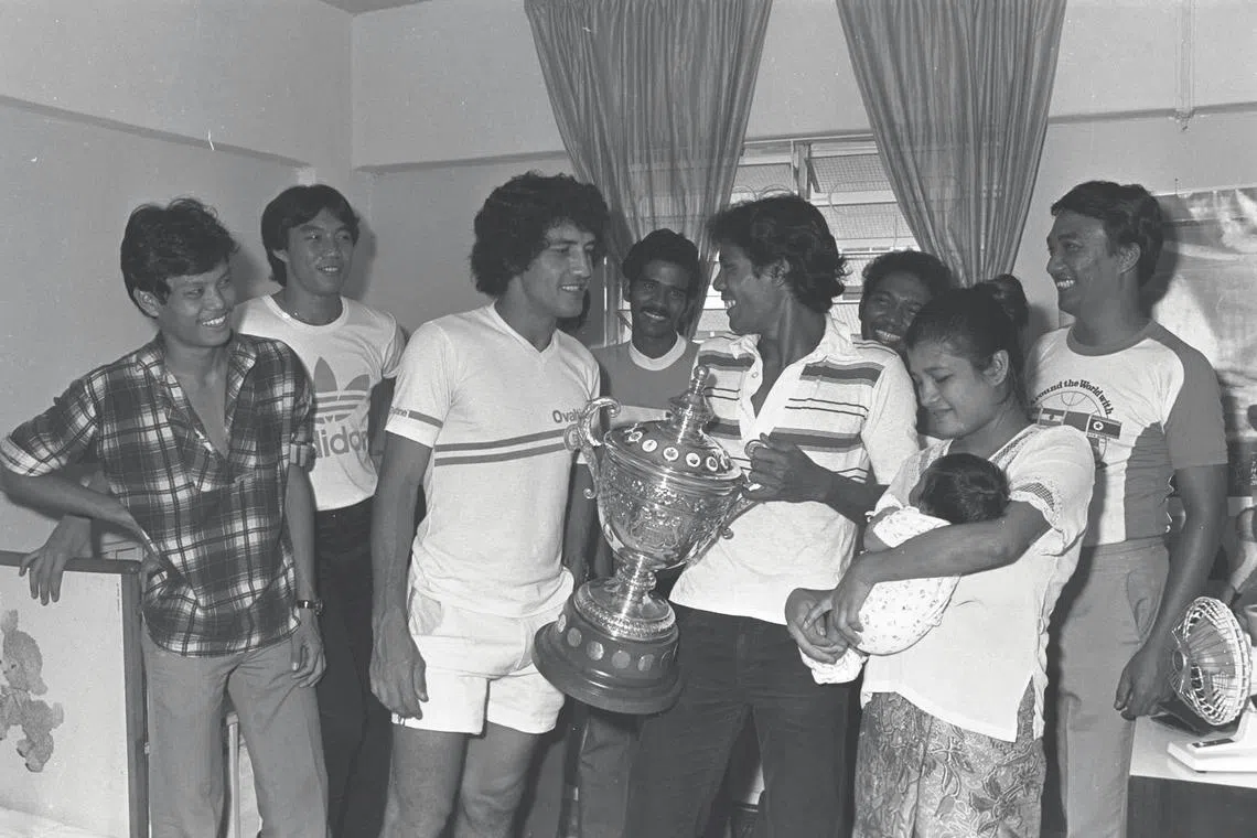 "We owe much of our victory to you," Singapore's national soccer team skipper, Samad Alapitchay, (3L, in full white) seems to be saying to Mohammed Noor Aishamuddin, who is in the arms of his mother, Munifah, as his proud father, Hasli Ibrahim (holding the Malaysia Cup). The rest of the team from left: Au-yeong Pak Kuan, David Lee, Rahim Hussein, S. Manokaran and coach Jita Singh.