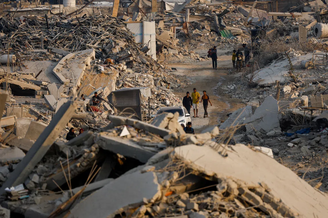 Palestinians walk past the rubble of destroyed buildings, amid a ceasefire between Israel and Hamas, in Jabalia, in the northern Gaza Strip, on Nov 6.