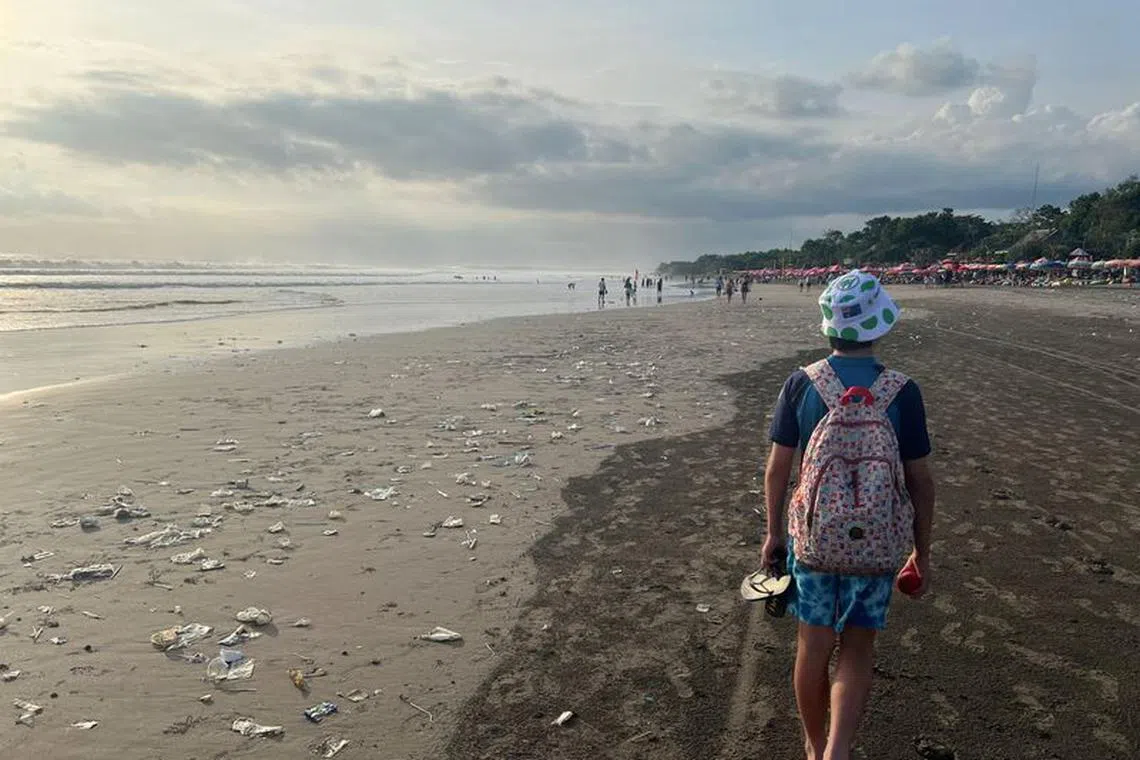 FILE PHOTO: A boy walks on a beach polluted by plastic trash in Bali, Indonesia, April 17, 2023. REUTERS/Ian Ransom