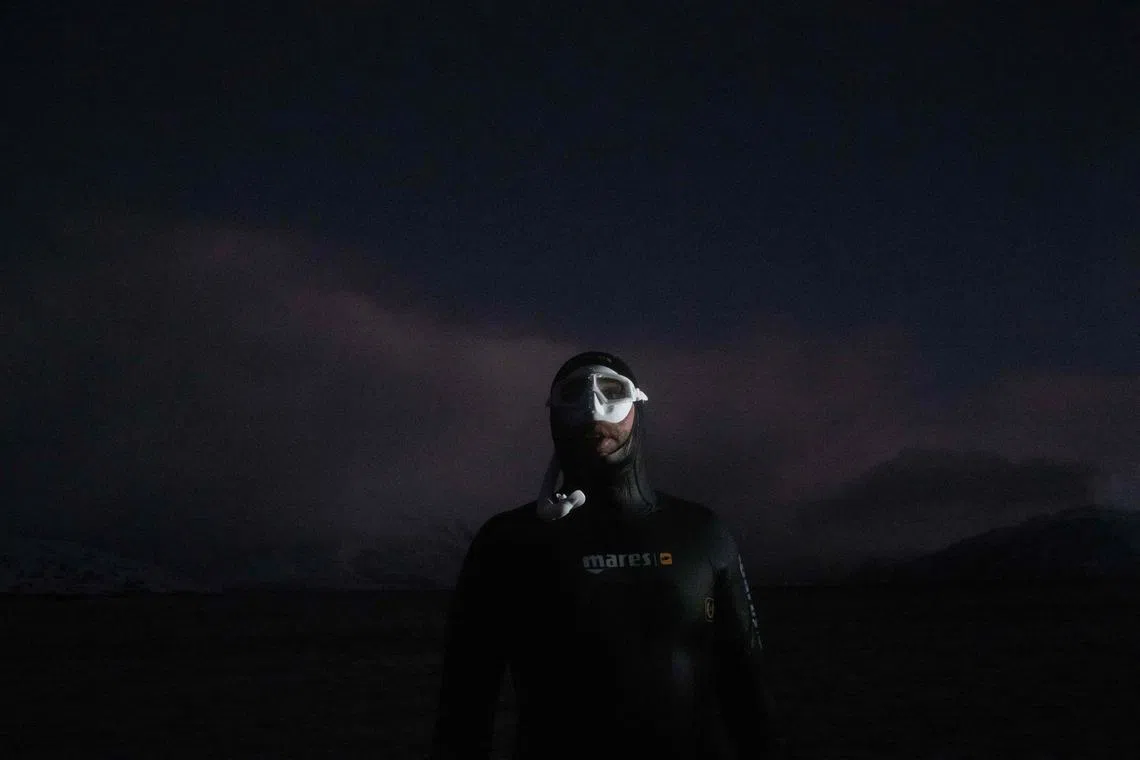 Five times freediving World Champion France's Arthur Guerin-Boeri comes out the water after trying to spot Orcas (Killer Whales) in the polar night, in the Spildra Island northern Arctic Circle, on Jan 26, 2023. 