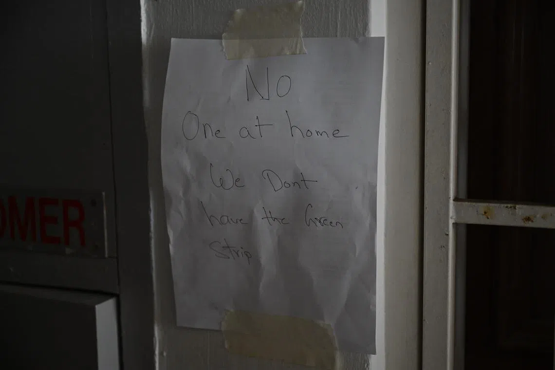 A resident without a tag provided by the police posted a handwritten notice outside their unit at 154 Gangsa Road. ST Photo: AZMI ATHNI