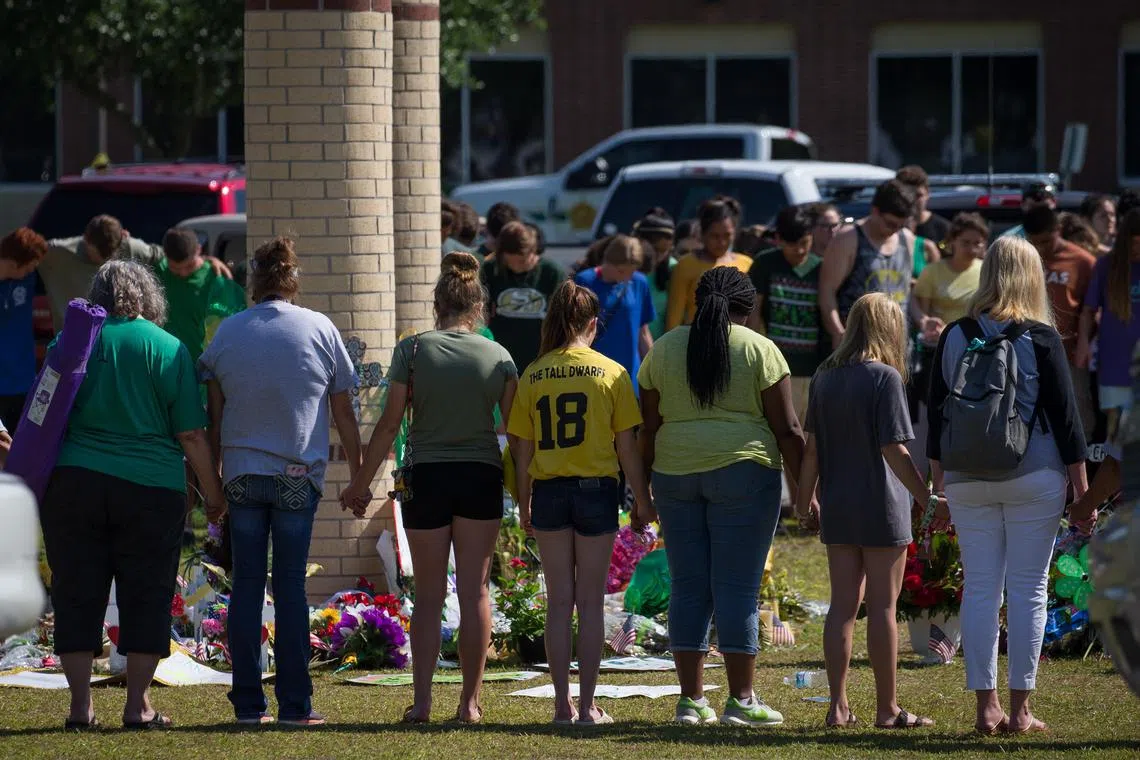 Mourners visit the memorial for shooting victims outside Santa Fe High School in Santa Fe, Texas on May 29, 2018. 