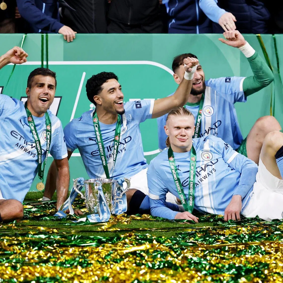 From left: Manchester City players Matheus Nunes, Jeremy Doku, Rodri, Omar Marmoush, Erling Haaland, Gianluigi Donnarumma, Savinho and Nico O'Reilly celebrating with the trophy after beating Arsenal 2-0 in the League Cup final at Wembley in London on March 22.