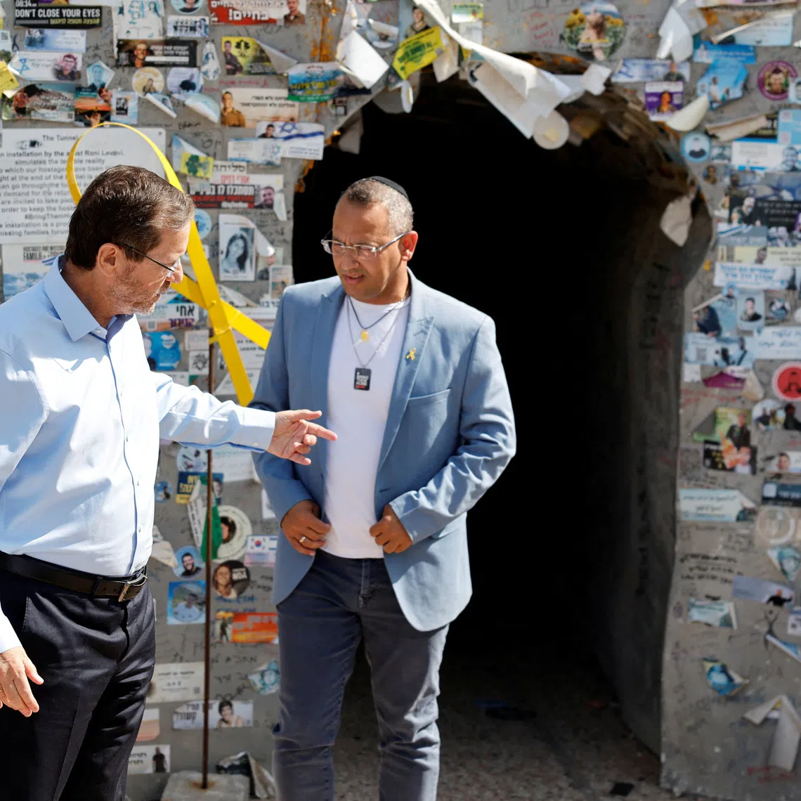 FILE PHOTO: Israeli President Isaac Herzog interacts with Sharon Sharabi, brother of Eli Sharabi, a former Israeli hostage released by Hamas, during his visit to Hostages Square, after families of hostages called for a nationwide strike to demand the return of all hostages and an end to the war in Gaza, in Tel Aviv, Israel, August 17, 2025. REUTERS/Amir Cohen/File Photo