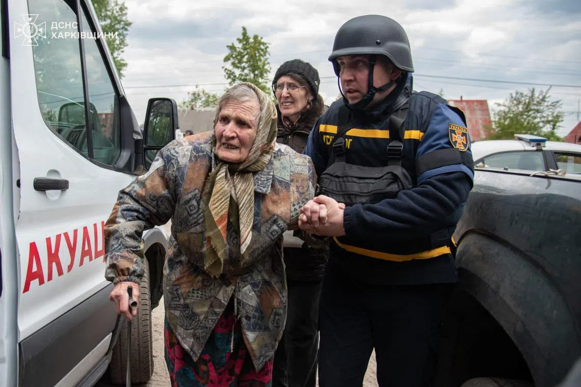 TOPSHOT - This handout photograph taken and released by Ukrainian Emergency Service on May 17, 2024, shows rescuers evacuating an elderly civilian from Russian shelling in Kharkiv region. Moscow seized 278 square kilometres (107 square miles) of Ukrainian territory between May 9 and 15, according to AFP calculations based on data from the Institute for the Study of War (ISW) -- the largest territorial gain in a single operation since mid-December 2022. (Photo by Handout / Ukraine Emergency Service / AFP) / RESTRICTED TO EDITORIAL USE - MANDATORY CREDIT "AFP PHOTO / UKRAINIAN EMERGENCY SERVICE " - NO MARKETING - NO ADVERTISING CAMPAIGNS - DISTRIBUTED AS A SERVICE TO CLIENTS