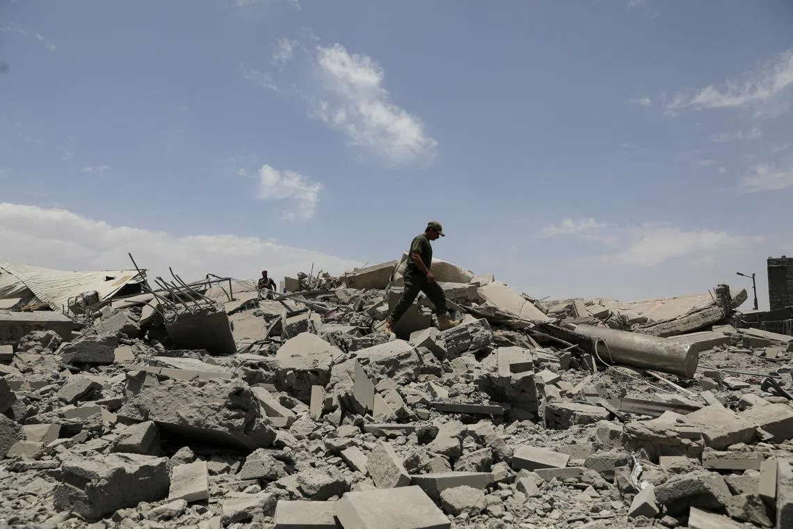FILE PHOTO: A police trooper walks on the rubble of a building destroyed by U.S. air strikes in Sanaa, Yemen April 27, 2025. REUTERS/Khaled Abdullah/File Photo
