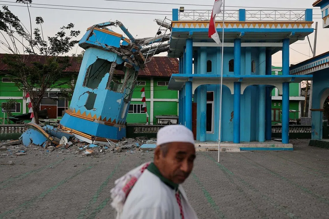 A person walks past the heavily damaged Nurul Huda mosque following an earthquake in Reok, East Nusa Tenggara province, Indonesia, August 18, 2026. REUTERS/Willy Kurniawan TPX IMAGES OF THE DAY