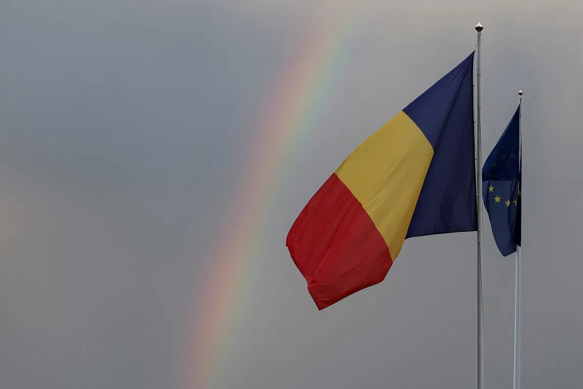 Romanian and European Union flags flutter, with a rainbow in the background, outside the Parliament, on the day of the Romania's second round of the presidential election, in Bucharest, Romania, May 18, 2025. REUTERS/Louisa Gouliamaki/File Photo
