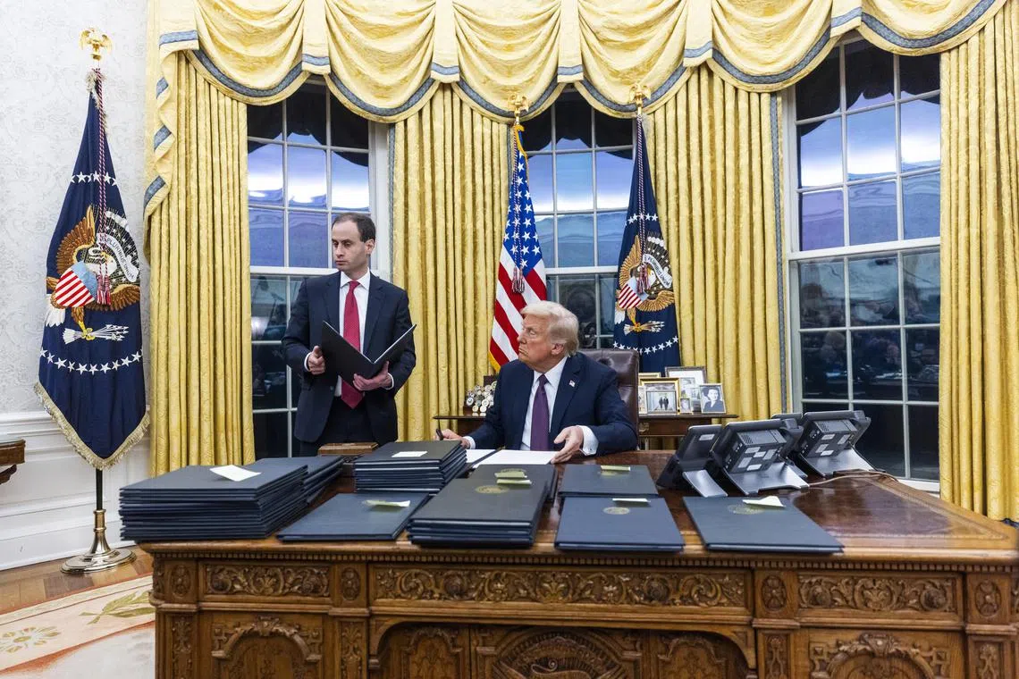 epa11840856 US President Donald Trump signs numerous executive orders, including pardons for defendants from the January 6th riots and a delay on the TikTok ban, on the first day of his presidency in the Oval Office of the White House in Washington, DC, USA, 20 January 2025. Trump, who defeated Kamala Harris to become the 47th president of the United States, was sworn in earlier in the day, though the planned outdoor ceremonies and events were cancelled due to extremely cold temperatures.  EPA-EFE/JIM LO SCALZO / POOL