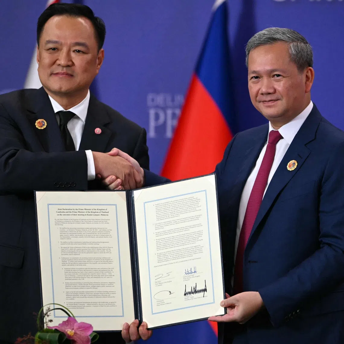 Cambodia's Prime Minister Hun Manet (R) and Thailand's Prime Minister Anutin Charnvirakul shake hands as they hold a signed document during a ceremonial signing of a ceasefire agreement on the sidelines of the 47th Association of Southeast Asian Nations Summit in Kuala Lumpur on Oct 26.