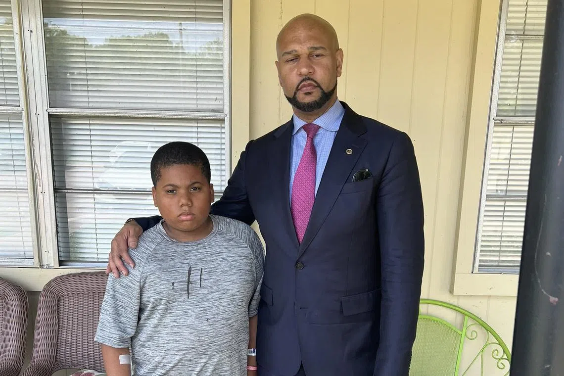 Aderrien Murry, 11, with family attorney Carlos Moore, after Aderrien was shot in Indianola, Mississippi.