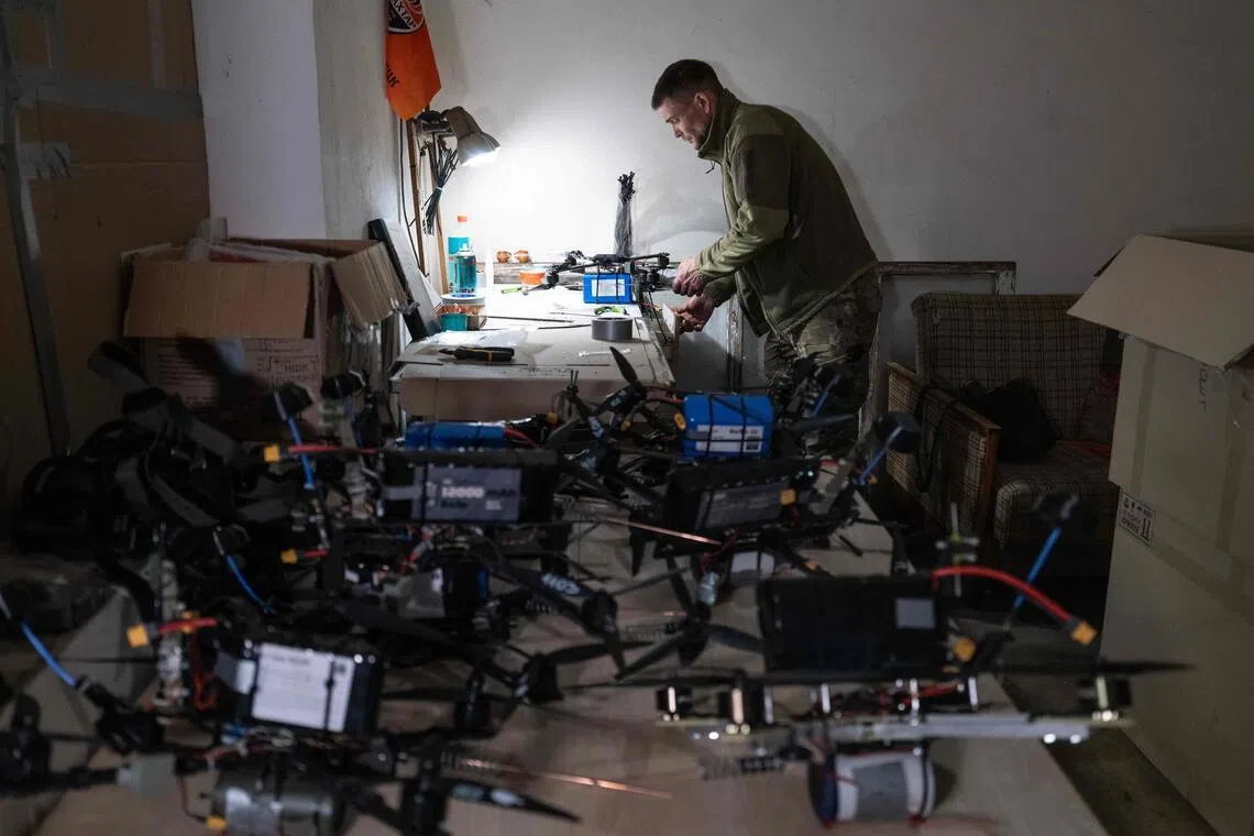 A Ukrainian soldier prepares drones at an undisclosed location near the frontline as war with Russia rages on.
