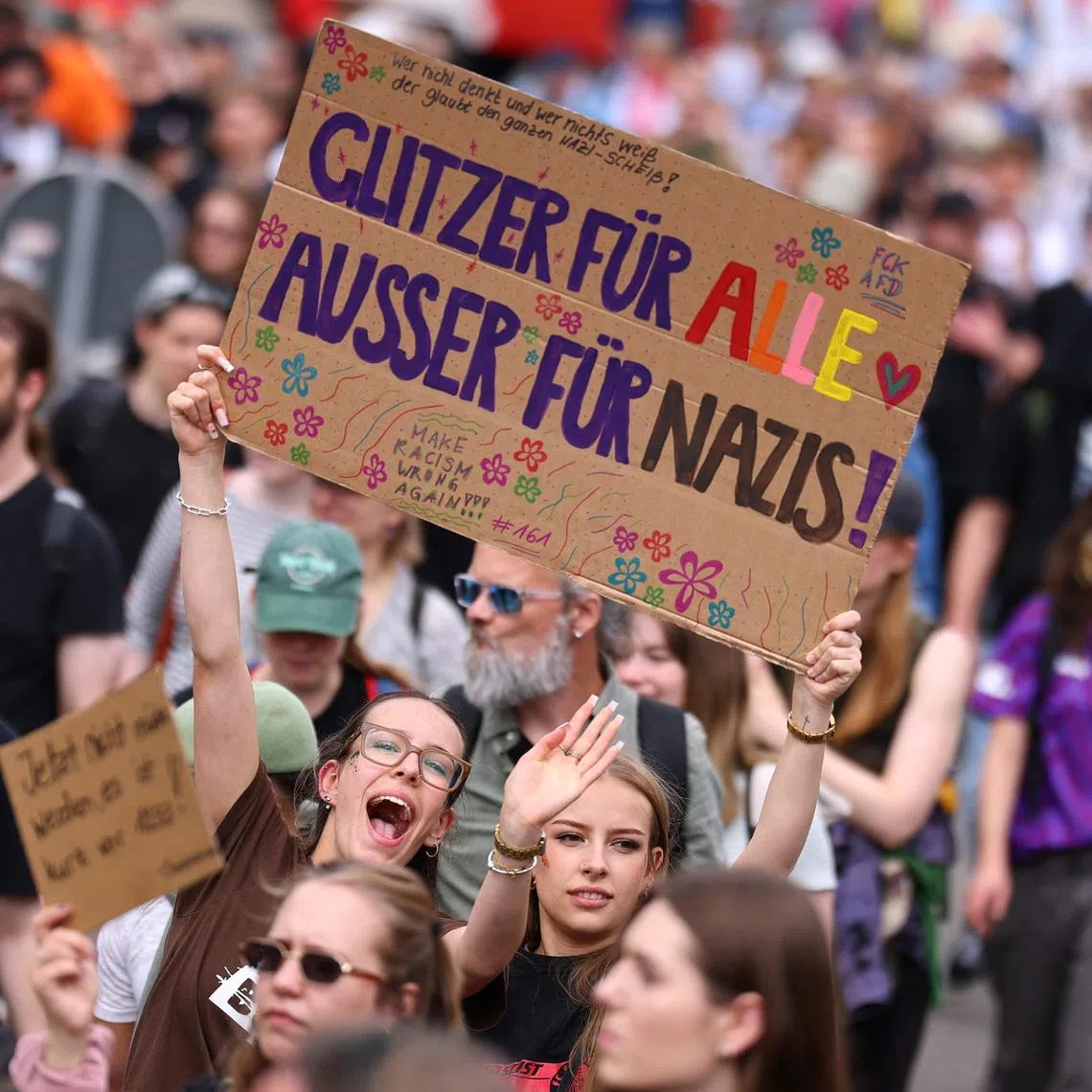 People hold a sign that reads: \"Glitter for everyone, except for Nazis\" during a protest against a two-day party convention of Germany's far-right Alternative for Germany (AfD) party, in Erfurt, Germany, July 4, 2026. REUTERS/Christian Mang