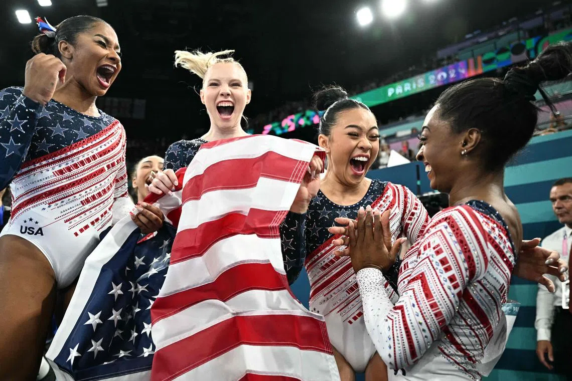 Simone Biles (right) and teammates celebrate after winning the artistic gymnastics women's team final.