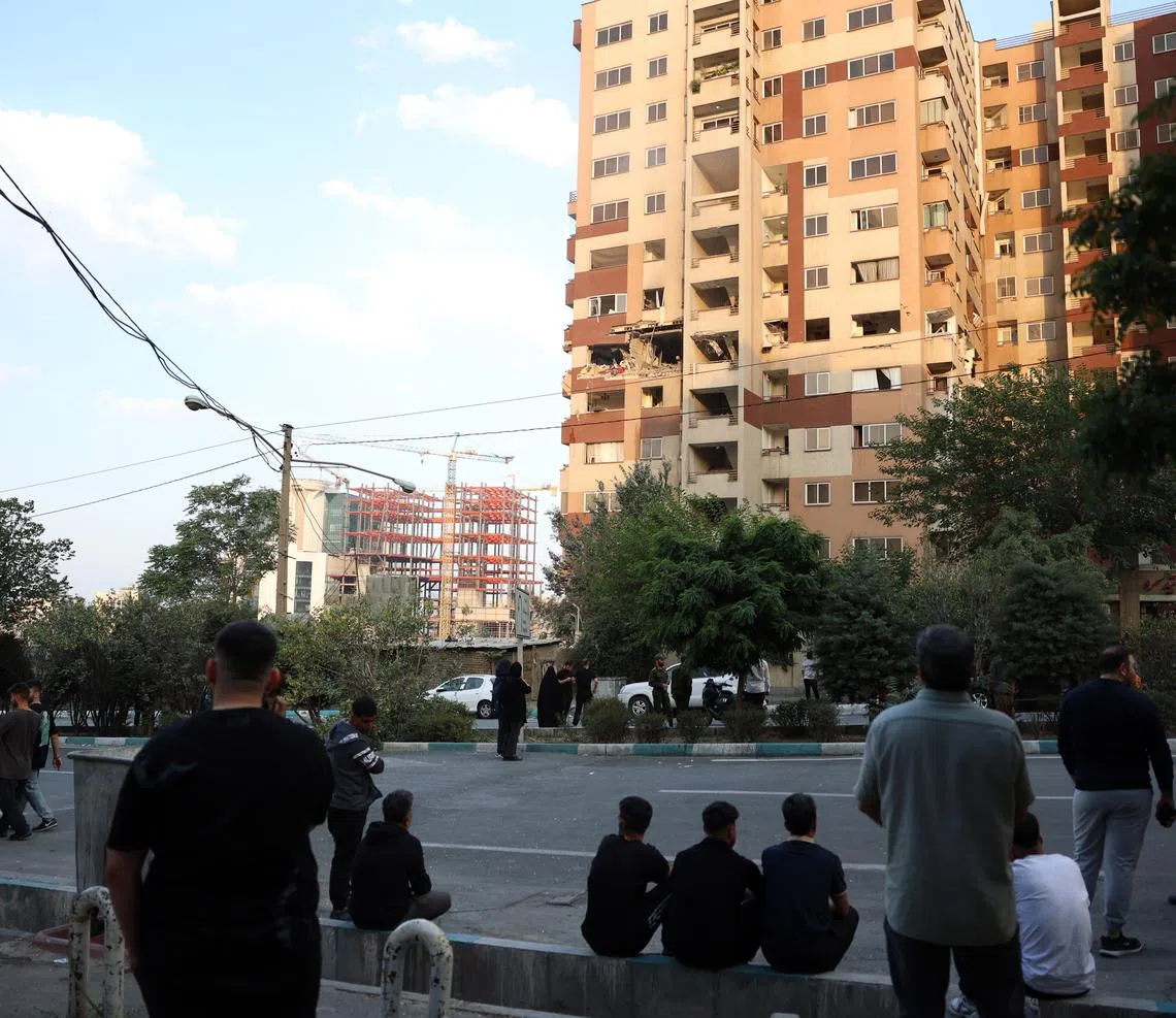 epa12172676 People gather outside a building that was hit by Israeli air stikes north of Tehran, Iran, 13 June 2025. Israel confirms it has launched strikes on Iran's 'nuclear program' as blasts are heard across the country. The strikes are part of Operation Rising Lion, Israel's Prime Minister Benjamin Netanyahu said, adding Iran was a threat to "Israel's very survival".  EPA-EFE/ABEDIN TAHERKENAREH