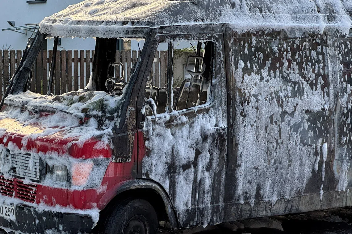 A burnt-out van is covered in foam after being extinguished by fire fighters in Munich, Germany, October 1, 2025. Police and firefighters were out in large numbers along Munich's Lerchenauer Strasse arterial road after a local newspaper reported that explosions and gunshots had been heard.     REUTERS/Ayhan Uyanik