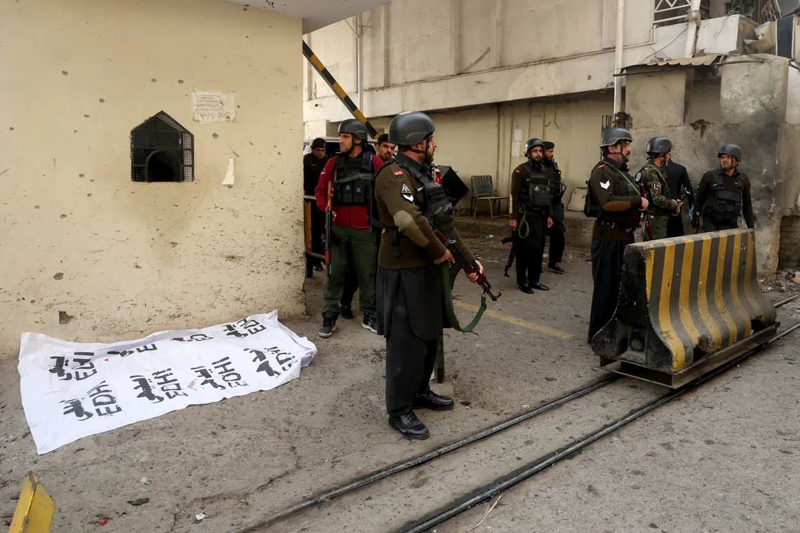Paramilitary soldiers standing near a body covered with a sheet, after suicide bombers targeted the headquarters of a Pakistani paramilitary force in Peshawar on Nov 24.