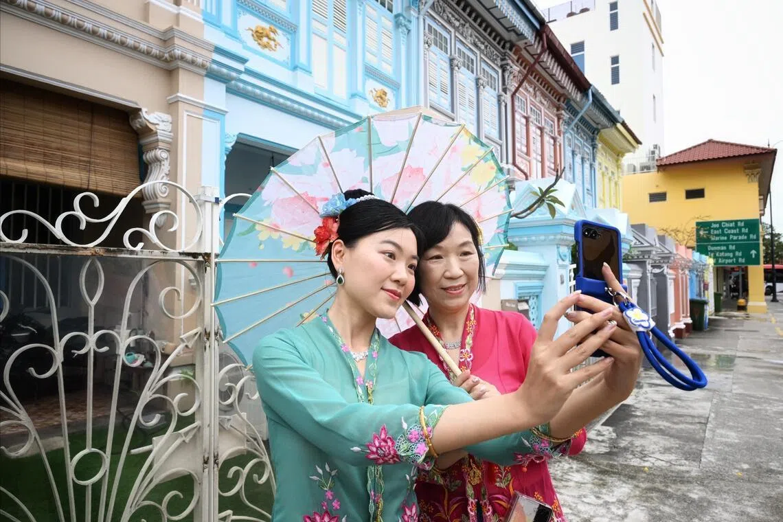 Tourists from China – Ms Cynthia Si, 30, and her mother, Ms Mia Cheng, 52 –  taking photos against the backdrop of colourful Peranakan houses in Koon Seng Road in Joo Chiat on Feb 20.