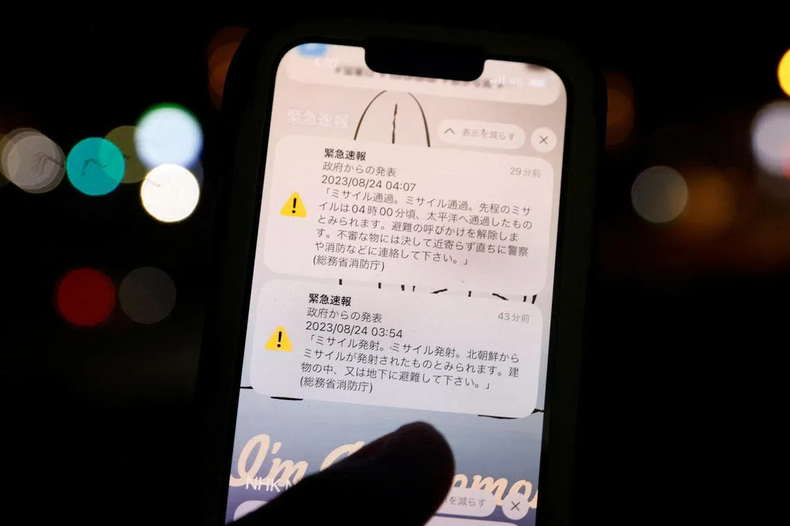 A smartphone screen shows the J-Alert warning  triggered by what appears to have been a space rocket launch by North Korea..